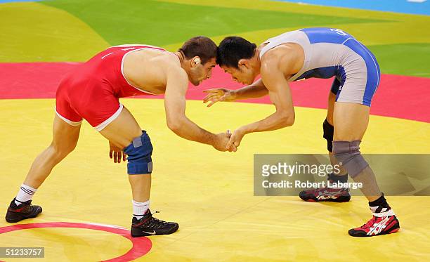 Kenji Inoue of Japan and Masuod Jokar of Iran compete during the men's Freestyle wrestling 60 kg semifinal round on August 29, 2004 during the Athens...