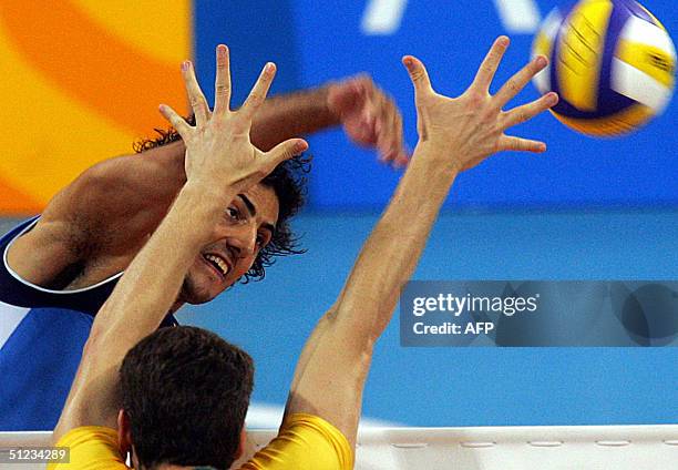 Italian Alessandro Fei spikes as Brazilian Gustavo Endres jump to block the ball during the gold medal volleyball match at the Olympic Games, 29...