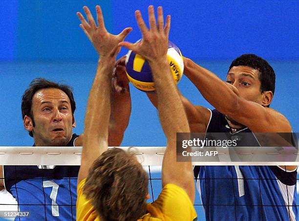 Italian Andrea Sartoretti and Luigi Mastrangelo jump to block the ball despite Brazilian Andre Heller during the gold medal volleyball match at the...