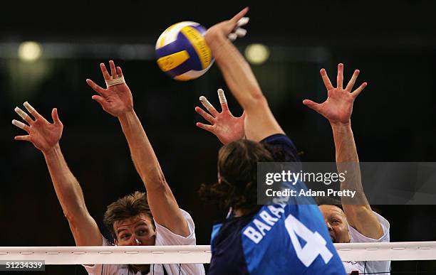 Thomas Hoff and Kevin Barnett of the United States jump to block the spike by Sergey Baranov of Russia during the men's indoor Volleyball bronze...