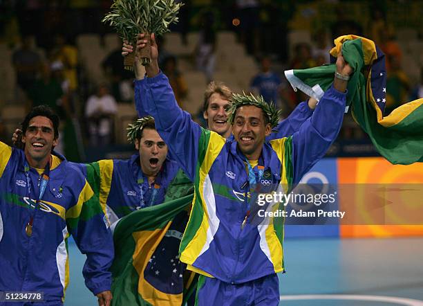 Sergio Dutra Santos of Brazil and teammates run off the podium after receiving the gold medal for men's indoor Volleyball during ceremonies on August...