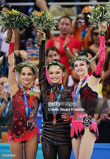 Irina Tchachina of Russia , Alina Kabaeva of Russia and Anna Bessonova of the Ukraine acknowledge their support during the medal ceremony for...
