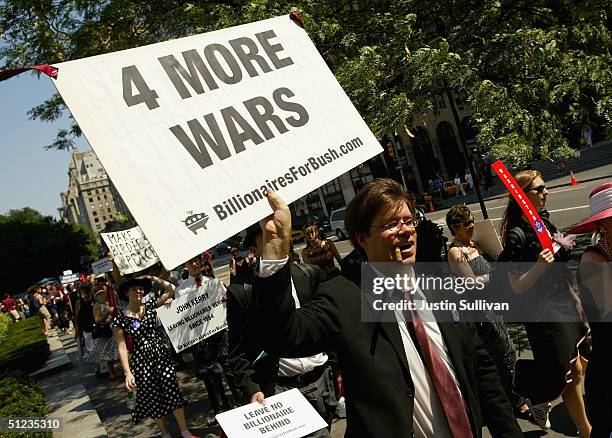 Member of the group "Billionaires for Bush" holds a sign as he marches down 5th Avenue during a protest march August 29, 2004 in New York City....