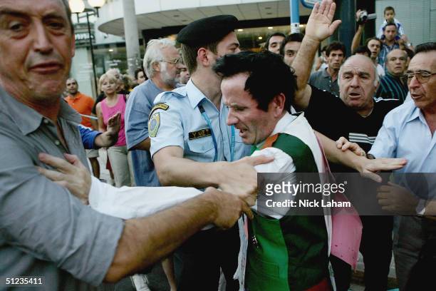 Cornelius Horan is stopped after tackling Vanderlei Lima of Brazil to the ground as he was leading in the men's marathon on August 29, 2004 during...