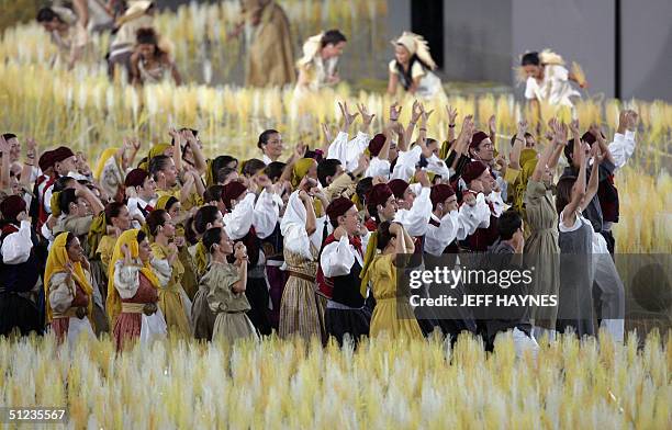 Dancers perform as traditional Greek harvesters around a spiral wheatfield made up of 45,000 individually 'planted' stalks at the Olympic Stadium 29...