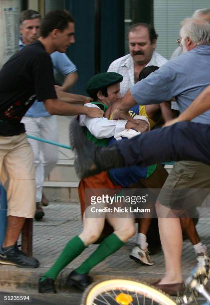 Cornelius Horan is stopped after tackling Vanderlei Lima of Brazil to the ground as he was leading in the men's marathon on August 29, 2004 during...