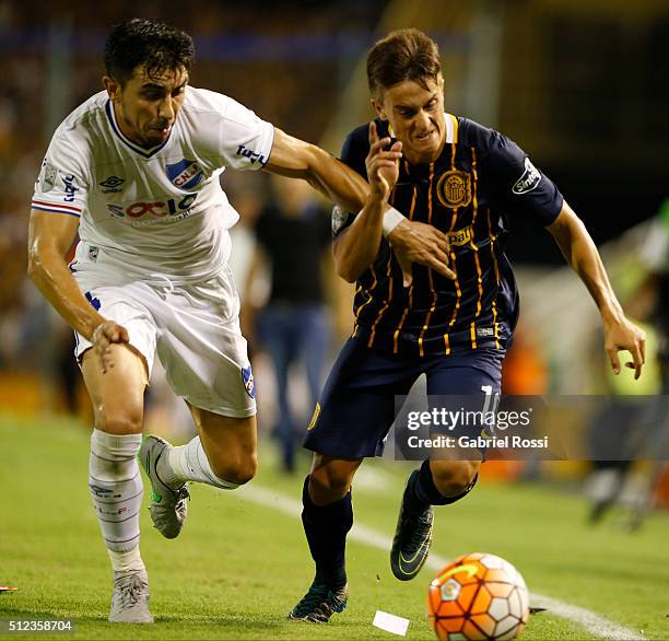 Franco Cervi of Rosario Central fights for the ball with Jorge Fucile of Nacional during a group stage match between Rosario Central and Nacional as...