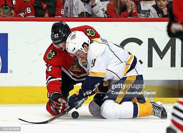 Filip Forsberg of the Nashville Predators and Trevor van Riemsdyk of the Chicago Blackhawks battle for the puck on their knees at the United Center...