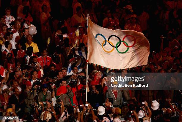 Dora Bakoyianni, mayor of Athens, carries the Olympic flag as she walks next to Wang Qishan, mayor of Beijing, the host city of the Games of the XXIX...