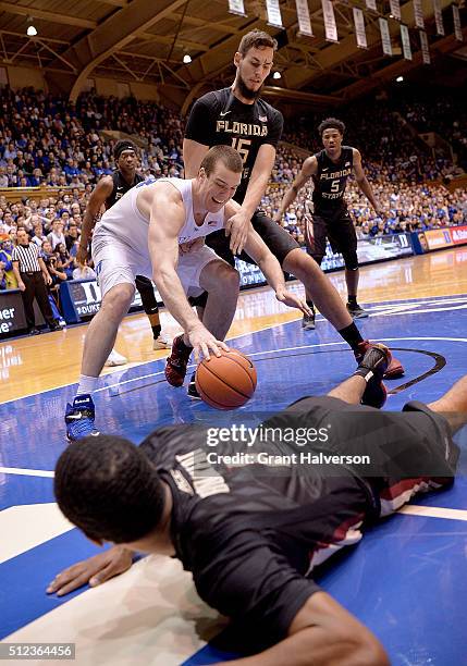 Marshall Plumlee of the Duke Blue Devils battles Boris Bojanovsky and Devon Bookert of the Florida State Seminoles for a loose ball during their game...