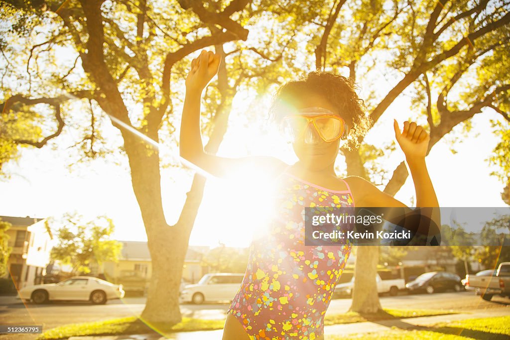 Girl in dancing in scuba goggles in garden