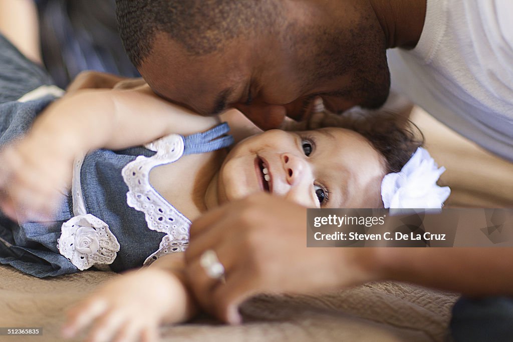 Father playing with baby daughter