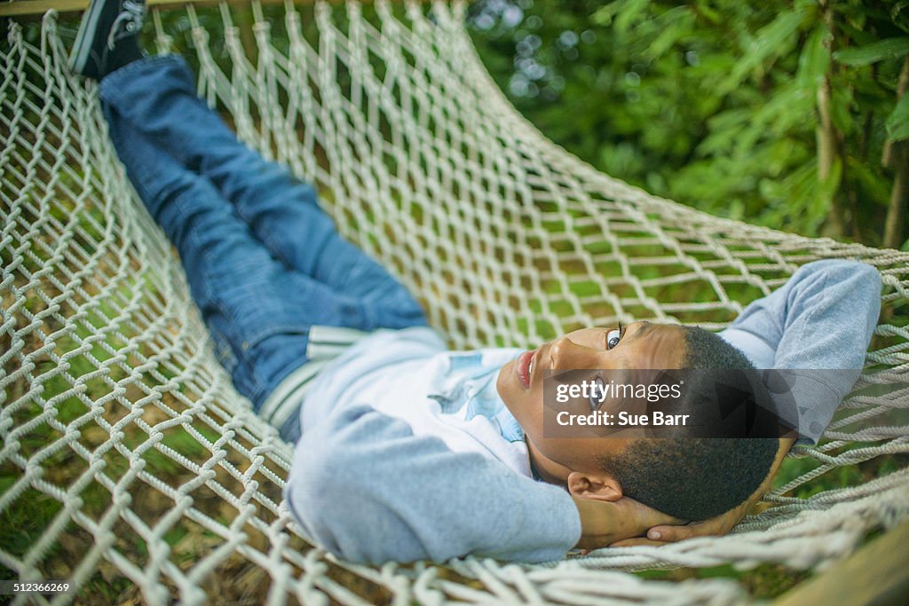 Teenage boy lying in hammock