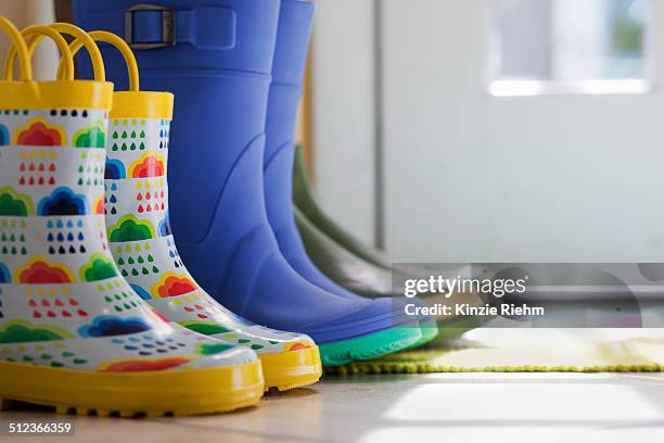 close up side view of row of rubber boots at back door - back door stock pictures, royalty-free photos & images