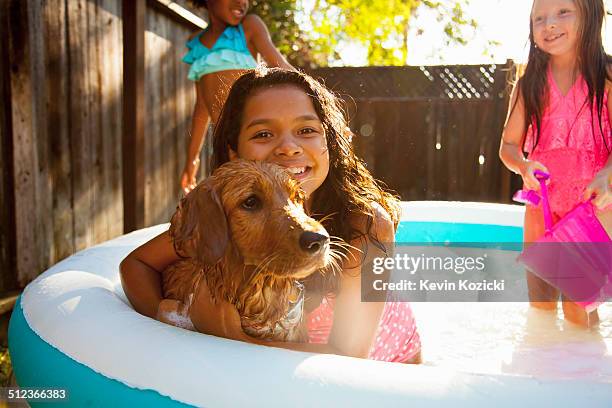 three girls and a dog in garden paddling pool - pretty latina girls stock pictures, royalty-free photos & images