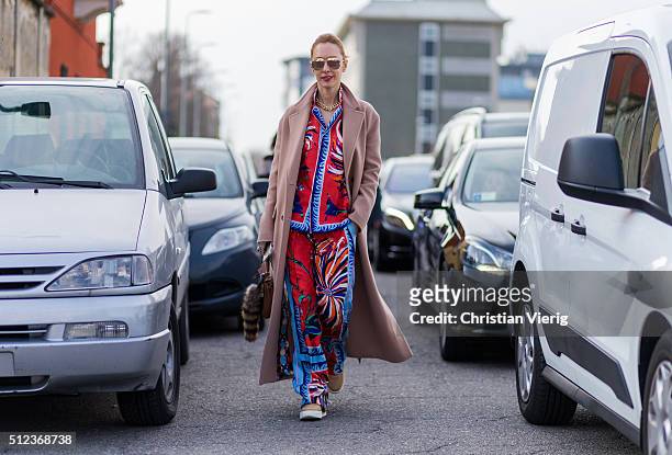 Elina Halimi wearing a printed Emilio Pucci pajama suit and a rose Celine wool coat and Dior shoes seen outside Emilio Pucci during Milan Fashion...