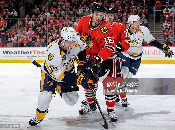 Craig Smith of the Nashville Predators and Artem Anisimov of the Chicago Blackhawks get physical during the NHL game at the United Center on February...