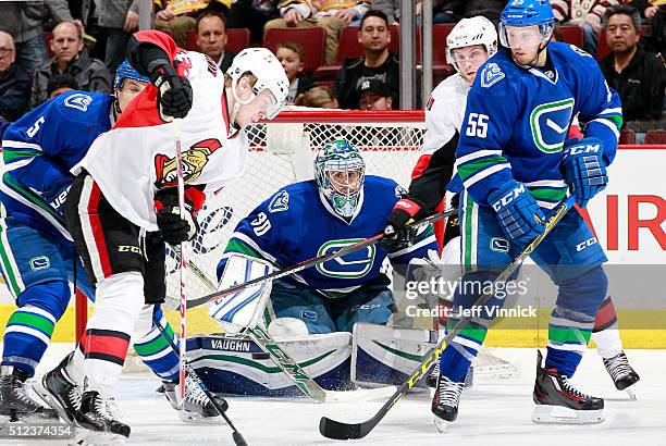 Ryan Miller of the Vancouver Canucks peers through a crowd for the puck during their NHL game against the Ottawa Senators at Rogers Arena February...