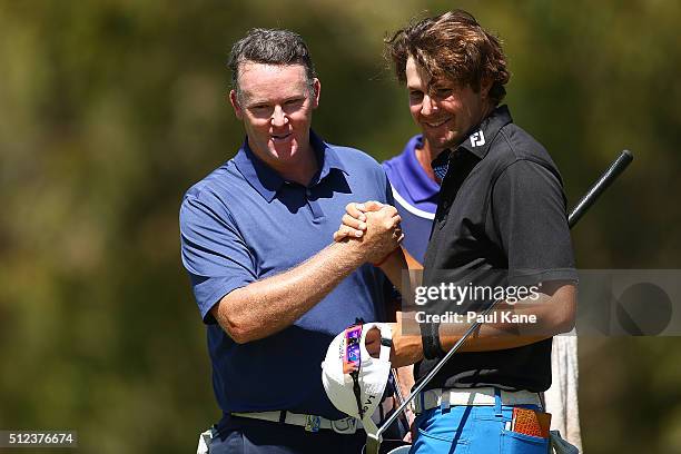 Marcus Fraser of Australia shakes hands with Peter Uihlein of the USA after the completion of their round during day two of the 2016 Perth...