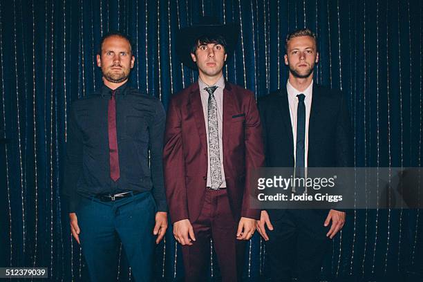 three men in suits standing together awkwardly - rigido foto e immagini stock