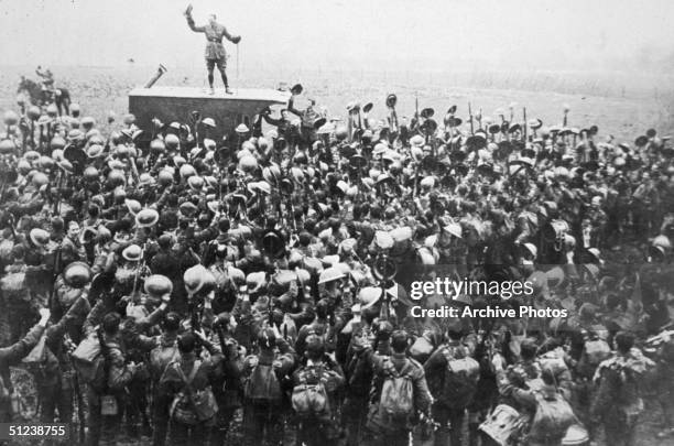 Crowd of soldiers on the Western Front celebrating as an officer announces the news of the armistice.