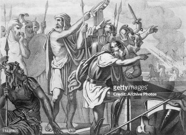 Circa 220 BC, Illustration of Greek mathematician and inventor Archimedes, , surrounded by armored soldiers who direct mirrors at invading Roman...