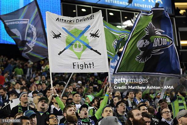 Fan of the Seattle Sounders holds up a flag saying Attack, Defend, Fight during the CONCACAF Champions League match between Seattle Sounders and Club...