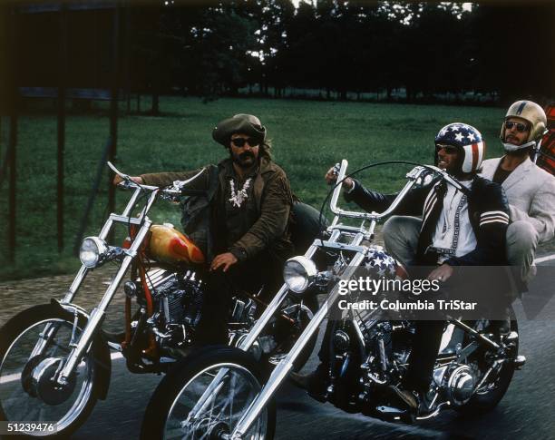 From left to right: American actors Dennis Hopper, Jack Nicholson and Peter Fonda ride through the countryside on motorcycles in a still from the...