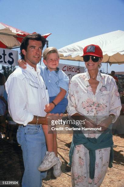 September 1989, Irish-born actor Pierce Brosnan carrying his son Sean with his wife Cassandra at a circus.