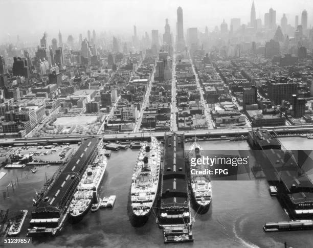 Circa 1940, Cunard and White Star liners berthing on the Hudson River in New York, with the Queen Mary in the centre.