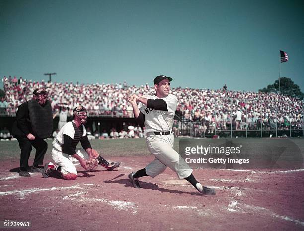 Circa 1955, American baseball player Yogi Berra, catcher for for the New York Yankees, swinging the bat during a game, 1950s.