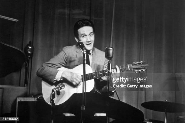 Circa 1965, American country singer, songwriter and musician Roger Miller playing the guitar on stage, 1960s.