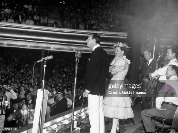Circa 1965, American actor and singer Jim Nabors performs onstage with American singer and comedian Minnie Pearl at the Grand Ole Opry, Nashville,...
