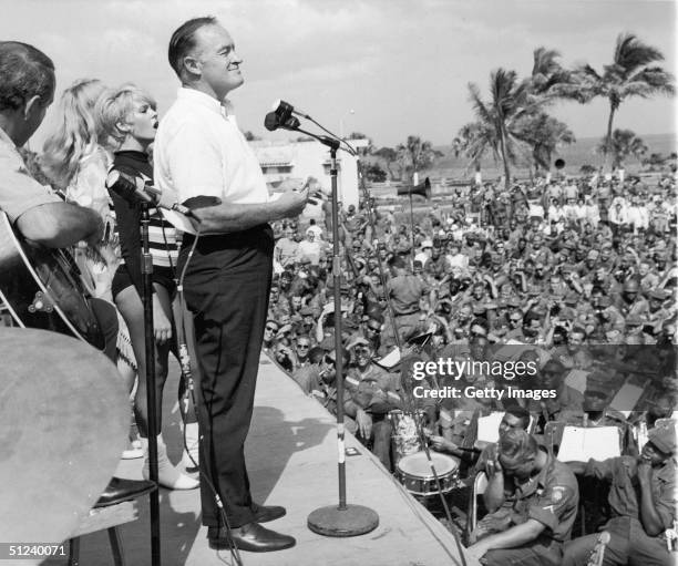 Circa 1965, British born American comedian and actor Bob Hope performs before US troops in front of the Hotel Hispanola, which was being used as...