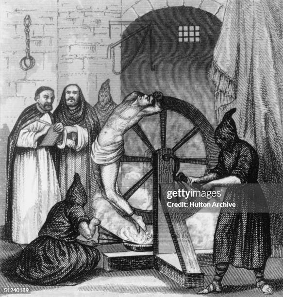 Circa 1500, A prisoner undergoing torture at the hands of the Spanish Inquisition. He is trapped to a revolving wheel below which a fire is being...
