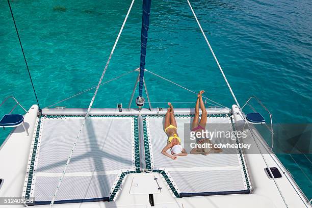 mujer relajante en catamarán en el caribe - catamarán fotografías e imágenes de stock