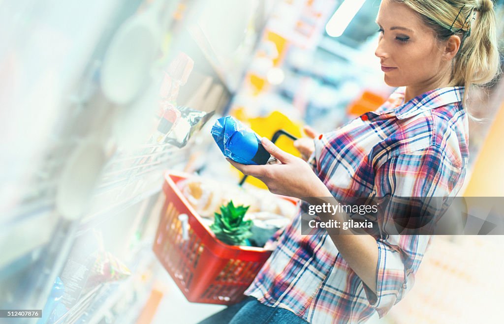 Woman buying food in supermarket.
