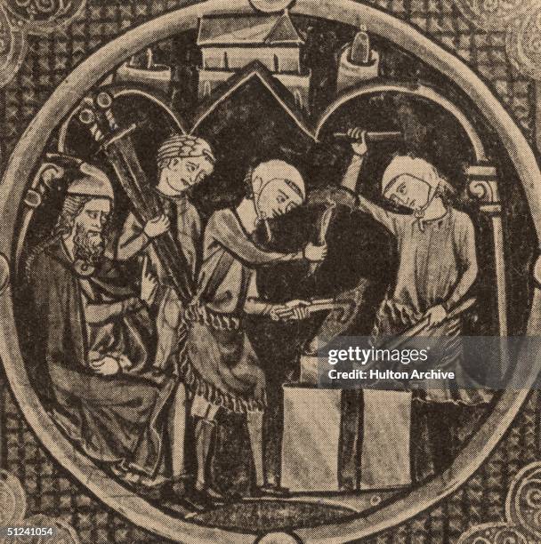 Circa 1275, Medieval smiths at work beating swords into shape on an anvil.