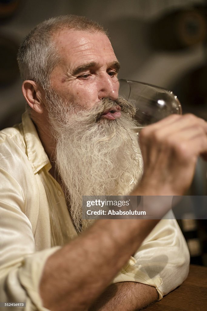 Senior Man with Long Beard Drinking White Wine, Europe
