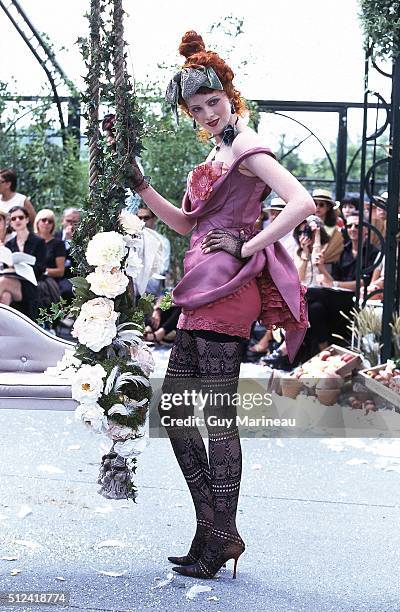 Model on the runway at the Belle Epoque inspired Fall/Winter 1997-1998 Christian Dior couture collection designed by John Galliano, wearing a purple...