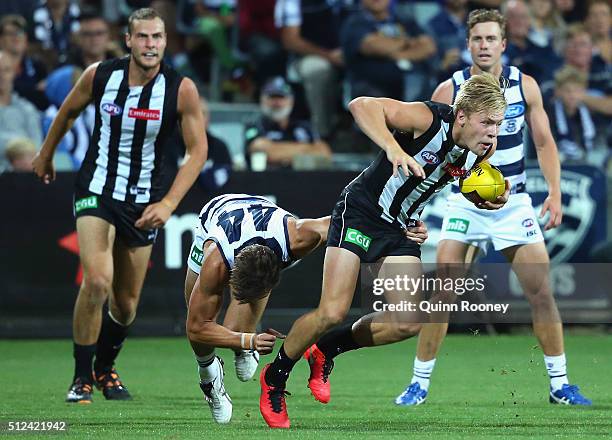 Jordan de Goey of the Magpies breaks free of a tackle by Corey Enright of the Cats during the 2016 NAB Challenge match between the Geelong Cats and...