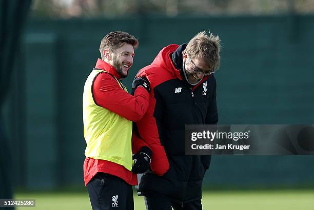 Liverpool manager Jurgen Klopp shares a joke with Adam Lallana during a training session ahead of their Capital One Cup final match against...