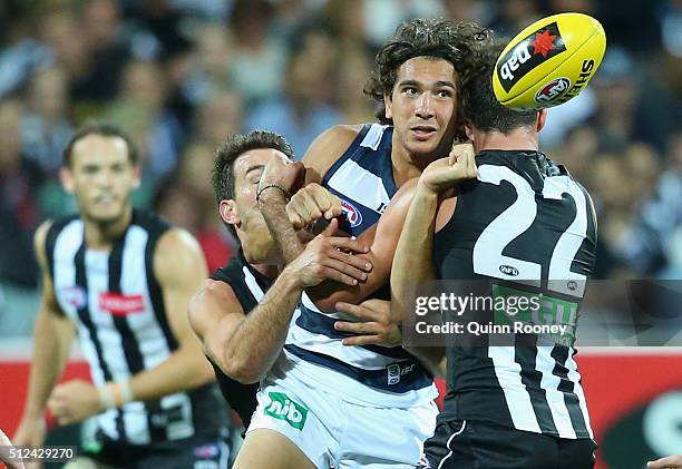 Nakia Cockatoo of the Cats handballs whilst being tackled by Steele Sidebottom of the Magpies during the 2016 NAB Challenge match between the Geelong...