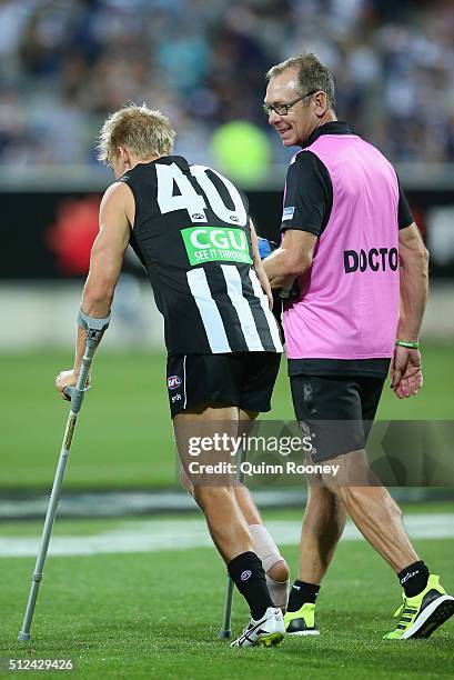 Josh Smith of the Magpies walks off on crutchers during the 2016 NAB Challenge match between the Geelong Cats and the Collingwood Magpies at Simonds...