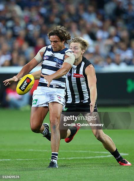 Steven Motlop of the Cats kicks whilst being tackled by Jordan de Goey of the Magpies during the 2016 NAB Challenge match between the Geelong Cats...