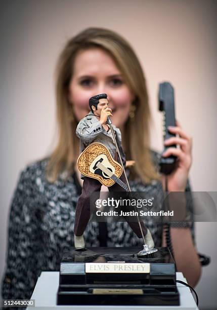 Sotheby's employee stands behind a novelty Elvis telephone during the pre-auction preview of the personal collection of Deborah Cavendish, Duchess of...