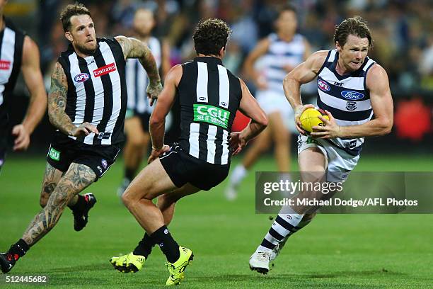 Patrick Dangerfield of the Cats runs with the ball away Dane Swan of the Magpies and Jarryd Blair during the 2016 NAB Challenge match between the...