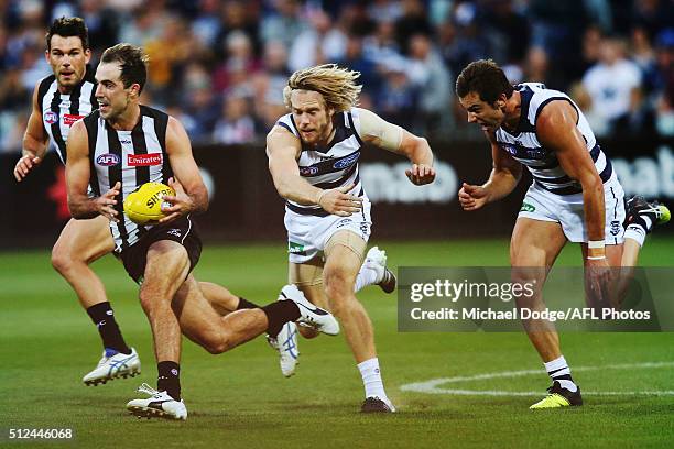 Steele Sidebottom of the Magpies runs with the ball away from Cameron Guthrie of the Cats during the 2016 NAB Challenge match between the Geelong...