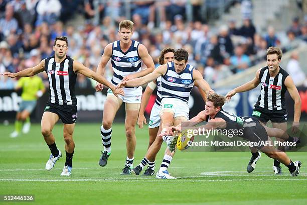 Jarryd Blair of the Magpies smothers the kick of Sam Menegola of the Cats during the 2016 NAB Challenge match between the Geelong Cats and the...