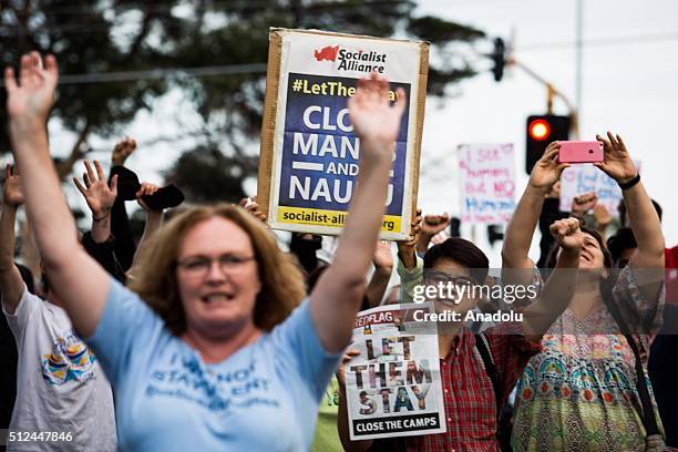 Protestors cheer and shout while holding placards outside a detention centre in Melbourne during a candlelight vigil as protestors stand in...